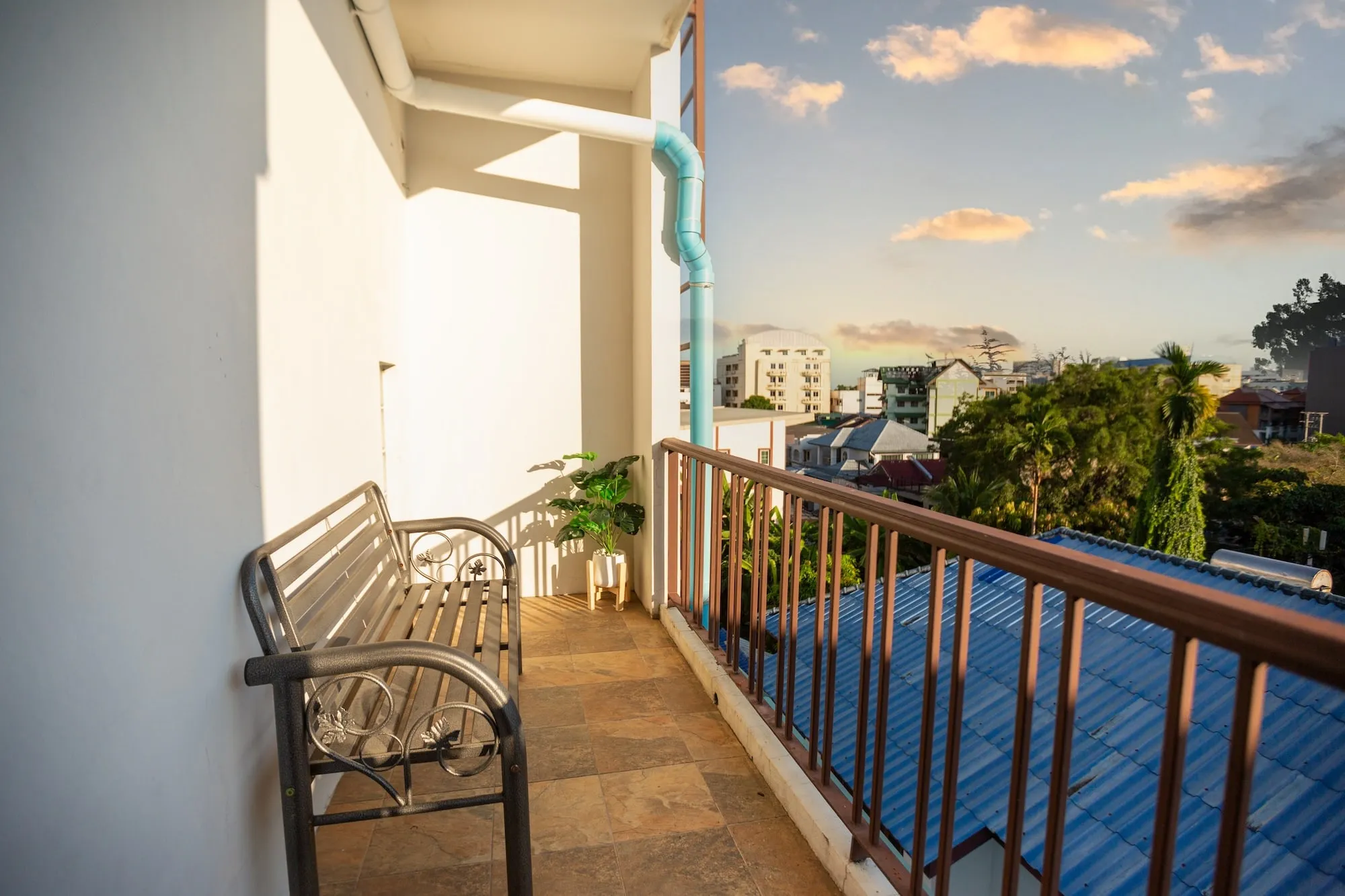 The Safehouse balcony at dusk, a bench looking out over Chiang Mai rooftops