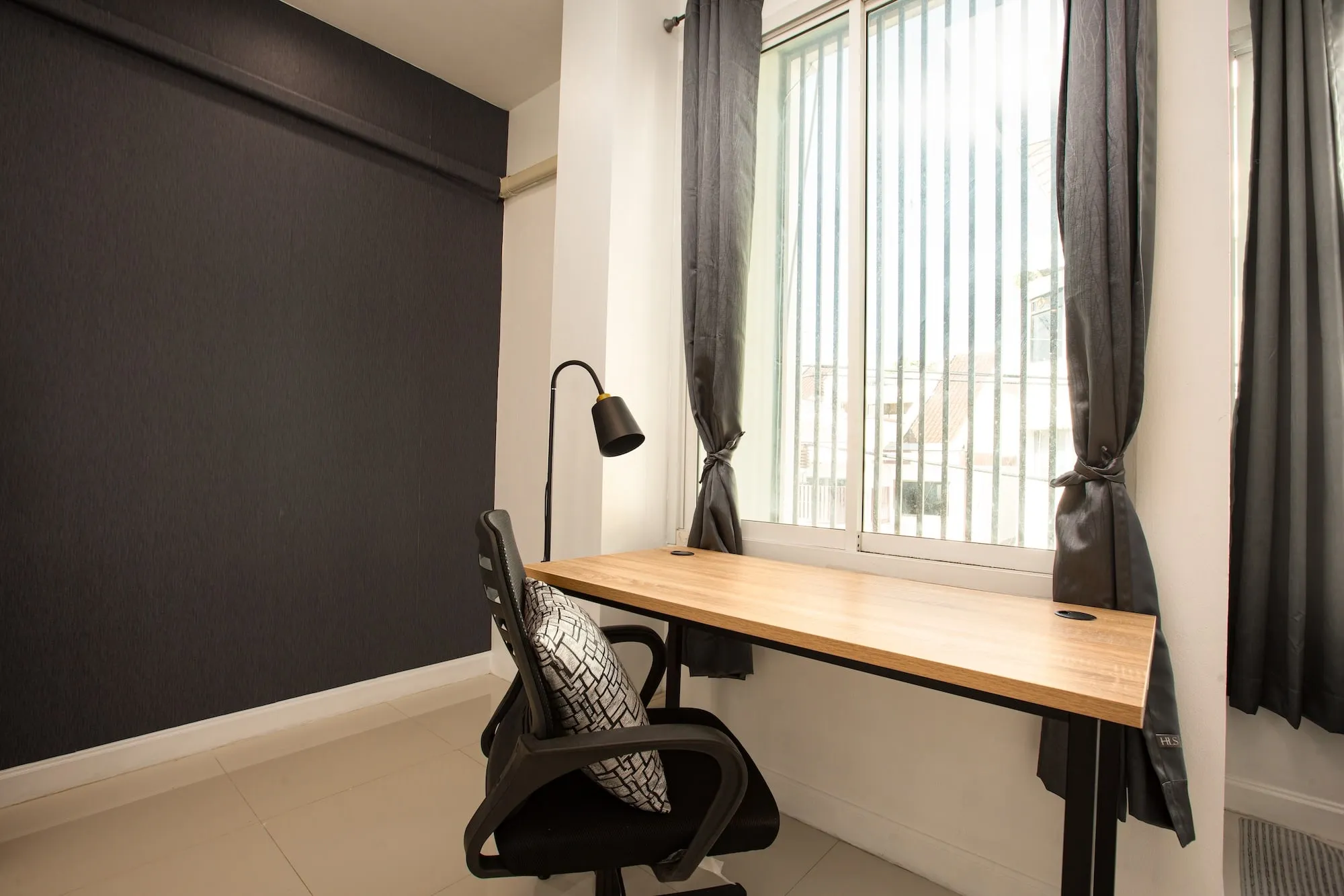The work desk in a Safehouse apartment, set under a window with an office chair